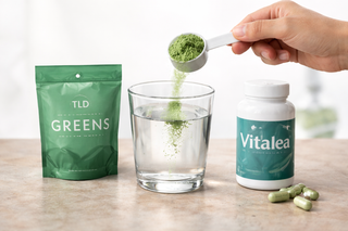 Hand stirring superfood drink with spoon in glass